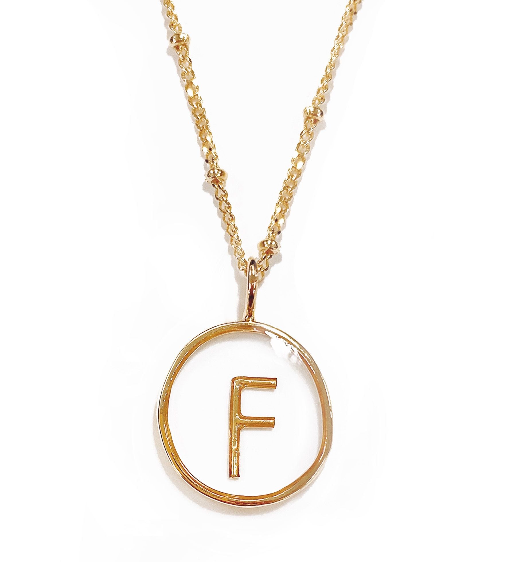 Collier doré lettre F en pendentif transparent - 172829
